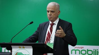 Homme d'affaires en costume lors d'une conférence avec fond vert.