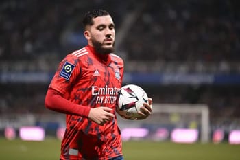 Rayan Cherki en tenue de football avec ballon sur le terrain.