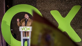 Homme politique parlant lors d'un rassemblement électoral avec logo VOX.
