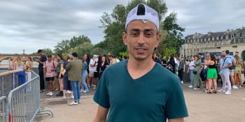 Homme en t-shirt vert et casquette blanche sauvant une femme en détresse.