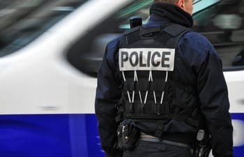 Agent de police en uniforme avec veste 'POLICE' en France.