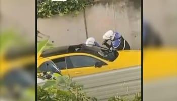 Deux policiers en intervention sur un taxi jaune en zone urbaine.