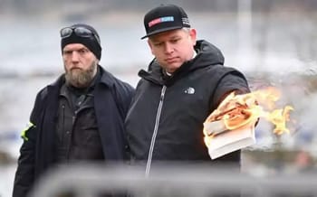 Jeune homme brûlant un livre lors d'une manifestation en Suède.