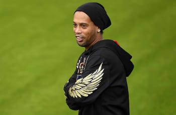 Ronaldinho portant un bonnet noir et un sweat à capuche avec des ailes dorées.