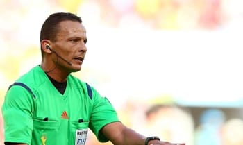 Arbitre algérien en action lors d'un match de football.