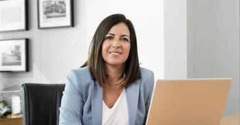 Femme d'affaires souriante travaillant sur un ordinateur portable.