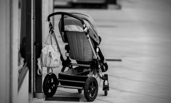 Poussette abandonnée dans un espace public, près d'une vitrine.