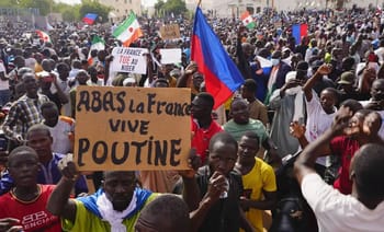 Grande manifestation en Afrique avec drapeaux et pancartes anti-français.