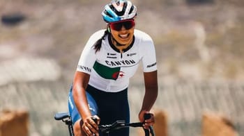 Cycliste algérienne portant un casque et une tenue de sport.