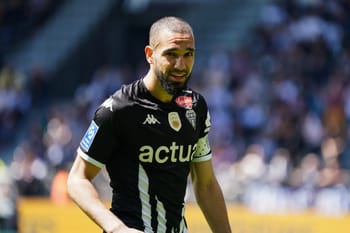 Nabil Bentaleb joueur de football algérien en pleine action sur le terrain.