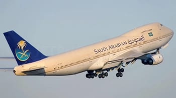 Avion de Saudi Arabian Airlines en plein vol dans le ciel clair.