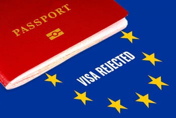 Passeport rouge sur fond de drapeau européen avec visa refusé.