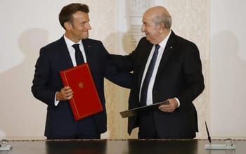 Deux hommes en costume signent un accord, échangeant un document officiel.