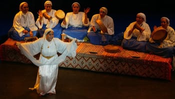 Groupe de musiciens et danseurs marocains en costume traditionnel.