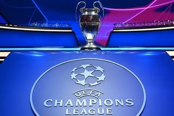 Trophée de la Ligue des Champions UEFA 2023-2024 sur une table bleue.