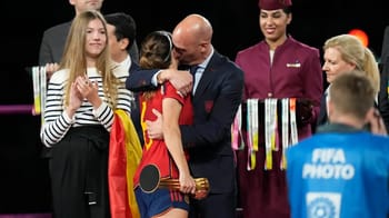 Un homme remet une médaille à une jeune athlète lors d'une cérémonie sportive.
