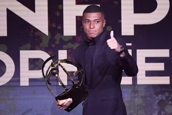 Kylian Mbappé avec un trophée lors d'une cérémonie de remise de prix.