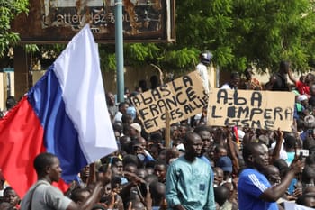 Manifestation au Niger avec drapeau français et pancartes.