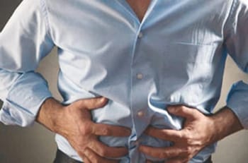 Homme souffrant de douleurs abdominales, symptôme d'intoxication alimentaire.