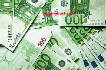 Billets d'euros de 100 et 200 euros avec dinar en arrière-plan.