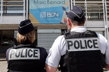 Deux policiers en uniforme surveillant une bibliothèque à Nîmes.