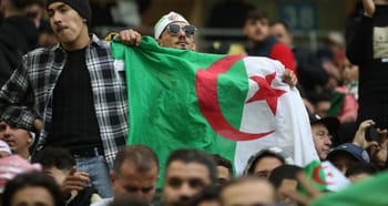 Supporters algériens avec drapeau national lors d'un événement sportif.