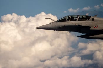 Avion de chasse F-16 en vol dans le ciel nuageux.