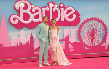 Couple posant devant un décor rose avec le logo Barbie et la grande roue.