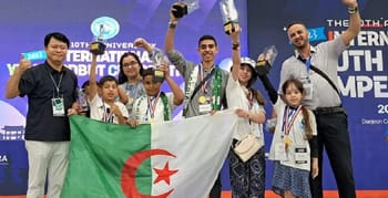 Groupe d'enfants et d'adultes avec la drapeau algérien et des médailles.