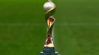 Trophée de la Coupe du Monde Féminine 2023 sur un terrain vert.