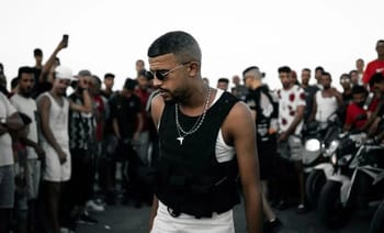 Hassen Junior, rappeur tunisien, entouré de fans lors d'un événement.