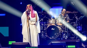 Cheb Khaled en tenue saoudienne lors d'une performance musicale.