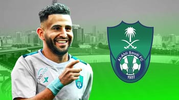 Riyad Mahrez souriant avec le logo d'Al Ahli Saudi FC.