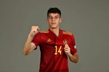 Jeune joueur espagnol en maillot rouge, prêt à jouer au football.