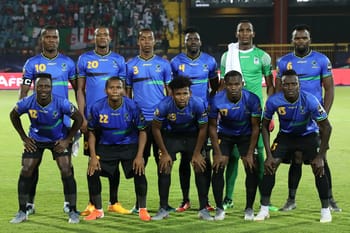 Groupe de joueurs de football tanzaniens en tenue officielle sur le terrain.
