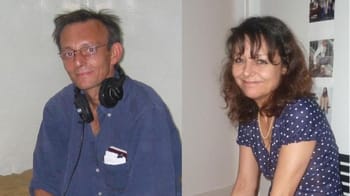 Deux journalistes, un homme et une femme, souriants, dans un studio de radio.
