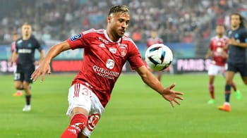 Youcef Belaili joue au football lors d'un match avec des coéquipiers et adversaires.