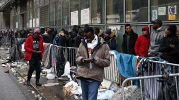 Personnes en attente derrière des barrières de sécurité en France.