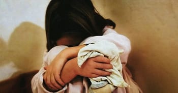 Enfant pleurant et se blottissant dans une étreinte protectrice.