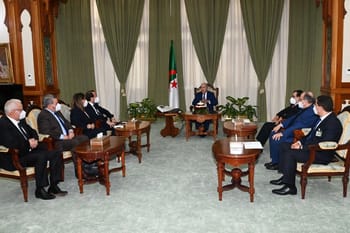 Le président algérien reçoit des dignitaires lors d'une réunion officielle.