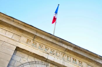 Drapeau français flottant au-dessus d'une préfecture en France.