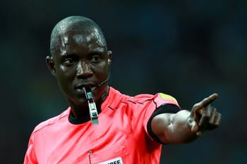 Arbitre de football avec sifflet, pointant lors d'un match.