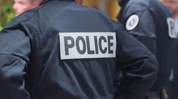 Policier en uniforme avec badge POLICE visible dans une scène de contrôle.