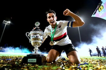Joueur de l'USM Alger célébrant la victoire avec la coupe de la CAF.