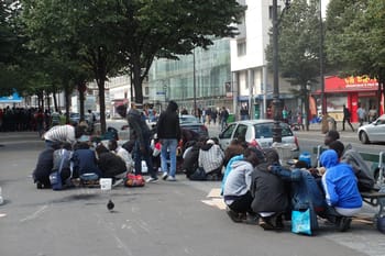 Groupe de personnes manifestant dans la rue pour la régularisation des sans-papiers.