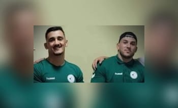 Deux athlètes algériens en maillot vert, souriants, lors des Jeux Méditerranéens de plage 2023.
