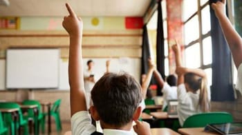 Étudiants en classe privée en Algérie levant la main.