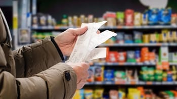 Personne tenant un ticket de caisse dans un supermarché.
