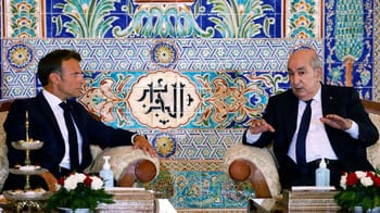 Deux hommes en discussion dans un décor traditionnel algérien.