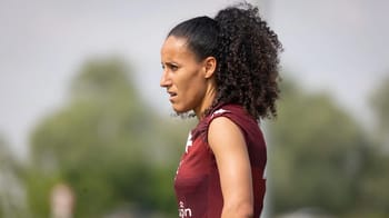 Femme sportive avec cheveux bouclés en action en plein air.